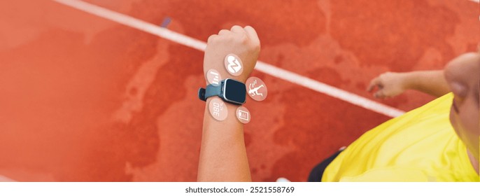 Male runner using smartwatch to track workout progress on the running track