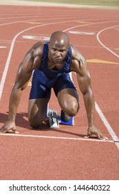 Male Runner Waiting At The Starting Block On Race Track