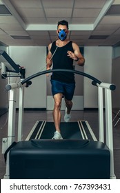 Male Runner Wearing Mask On Treadmill In Sports Science Laboratory. Sports Man Running On Treadmill And Monitoring His Fitness Performance.