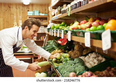 Male Sales Assistant At Vegetable Counter Of Farm Shop