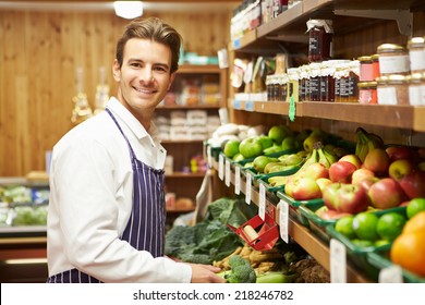 Male Sales Assistant At Vegetable Counter Of Farm Shop