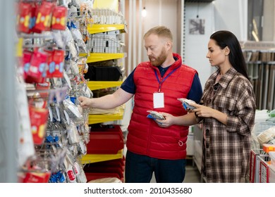 Male Sales Manager Helping Young Woman To Choose Goods In Hardware Store