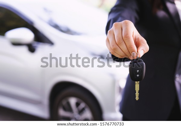 The male salesperson delivers the new car\
key back to the customer at the\
showroom.