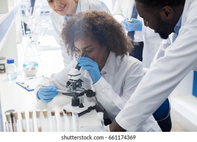 Male Scientist Working With Microscope, Team In Laboratory Doing Research, Man And Woman Making Scientific Experiments Doctors In Lab