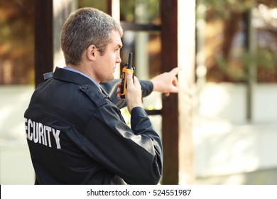 Male Security Guard Near Building Facade