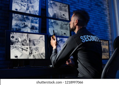 Male Security Guard With Portable Transmitter Monitoring Modern CCTV Cameras Indoors