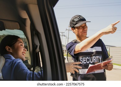Male security guard provides travel information young woman driving private car came to ask for travel information and pointed to the right direction to reach her destination and made her confident. - Shutterstock ID 2257067575
