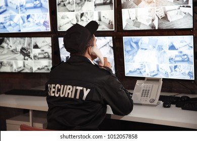 Male Security Guard Talking By Telephone In Surveillance Room