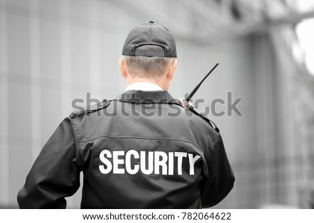 Male security guard using portable radio outdoors