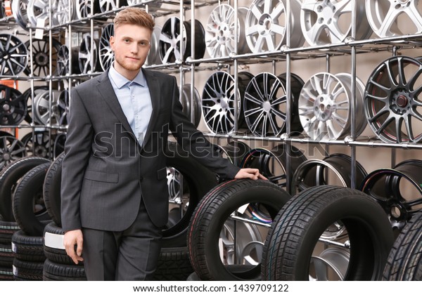 Male seller in car tire\
store