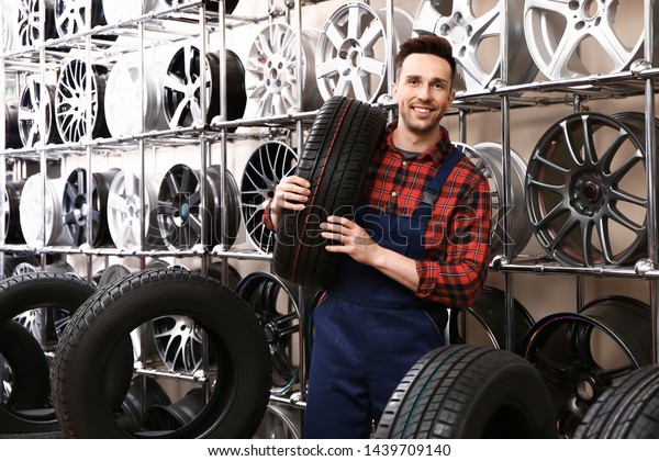 Male seller in car tire\
store