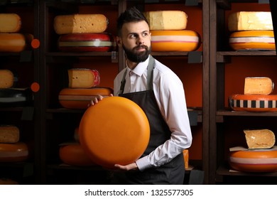 Male seller with delicious cheese in store - Powered by Shutterstock