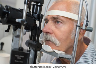 male senior in eye clinic examine eyes - Powered by Shutterstock