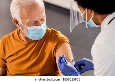 Male senior patient getting vaccinated at medical clinic during coronavirus pandemic.  - Powered by Shutterstock