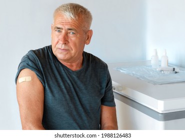 Male Senior Smiling After Receiving COVID-19 Vaccine. Elderly Man Feeling Good On Getting Vaccine From Coronavirus. Covid Vaccination For Older People. Senior Man Showing Her Arm With Bandage, Patch.