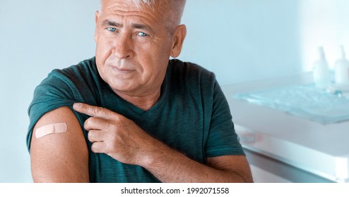 Male Senior Smiling After Receiving COVID-19 Vaccine. Elderly Man Feeling Good On Getting Vaccine From Coronavirus. Covid Vaccination For Older People. Senior Patient Showing Arm With Bandage, Patch.