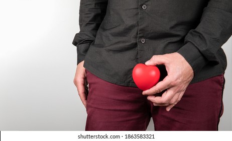 Male Sexual Health Concept. Man Holding Heart At Intimate Parts. Urinating And Prostate Problems.