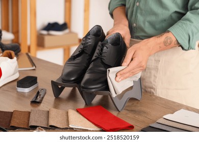 Male shoemaker cleaning shoes in repair shop, closeup - Powered by Shutterstock