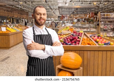 Male Shop Assistant In A Grocery Store Posing In Front Of Fruits