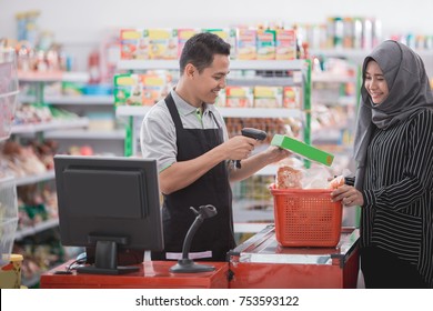 male shopkeeper scanning product barcode in supermarket - Powered by Shutterstock