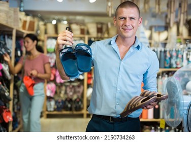 Male Shopper Chooses Beach Flip Flops At A Hardware Store