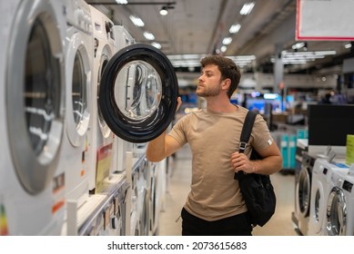 Male Shopper Looking Inside Washing Machine