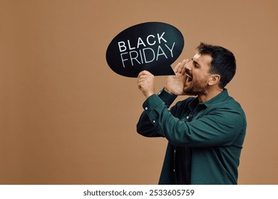 Male shopper shouting while holding Black Friday speech bubble. Copy space. - Powered by Shutterstock