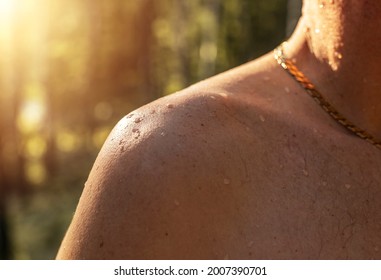 Male Shoulder With Water Drops On Tanned Skin Of Caucasian Human. Wet Droplets On Men Body, Close Up.