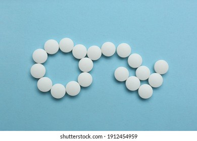 Male sign with bent arrow of white pills symbolizing potency problems on light blue background, flat lay