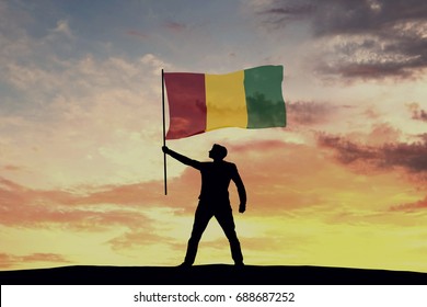 Male Silhouette Figure Waving Guinea Flag. 3D Rendering