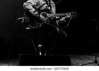 Male Singer Playing Guitar On Stage. Black And White High Contrast. Pop Singer. Live Concert, Instrumental. Concert Set. Unrecognizable Person. No Face Person. Grunge Concept