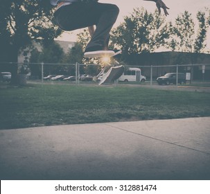 Male Skate Boarder Doing A Kick Flip At A Skate Park With A Toned Instagram Filter During Sunrise Or Sunset