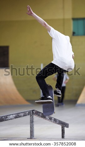 Similar – Image, Stock Photo Skateboarder performing a trick on a rail at a skatepark.