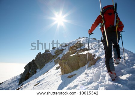 Male ski-climber climbing a snowy ridge; horizontal frame. Italian alps.