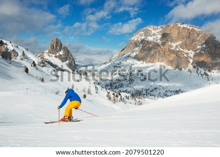 Male skier in blue and yellow clothes on slope with mountains in the background at Cortina d'Ampezzo Col Gallina Sella Ronda skiing resort area Dolomiti Italy Foto d'archivio © 