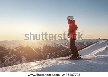 Male skier watching the sunset in the mountains