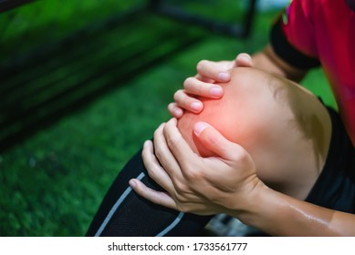 Male Soccer Player Suffering From Knee Injury On Field.