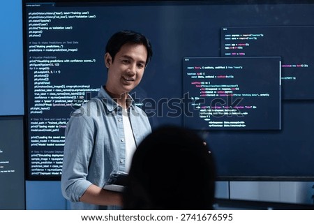 Male software engineer presenting a Coding Task, AI chatbot workflow with code on multiple monitors in a modern office. coding collaboration and agile projects Concept.