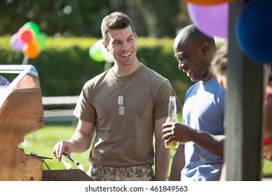 Male Soldier Barbecuing With Friends At Homecoming Party