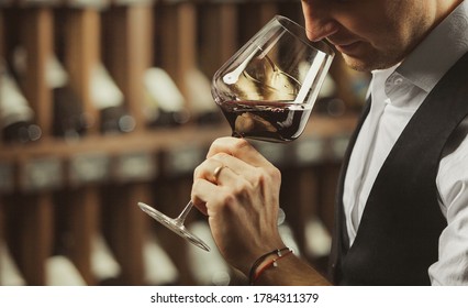 Male Sommelier Tasting Red Wine At Cellar.