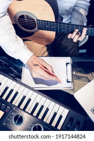 Male Songwriter Writing A Song With Laptop Computer And Keyboard On Desk. Songwriting Concept
