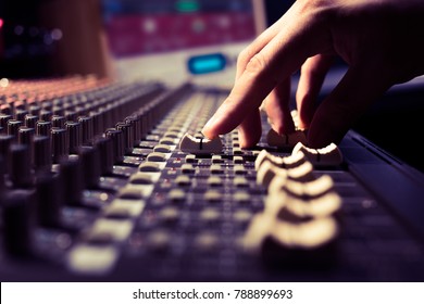 male sound engineer hands working on sound mixer for recording, broadcasting, music production background