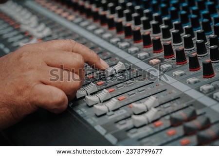male sound engineer hands working on sound mixer for recording, broadcasting, music production background