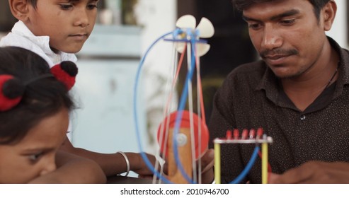 A Male South Asian Teacher Showing Children Educational Toys