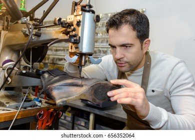 Male Specialist Fixing Heel Taps Of Shoes On Machine