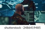 Male IT specialist operating on reconnaissance system to transmit real time data for new field mission, working in military command center. Telecommunications operator provides air support. Camera A.