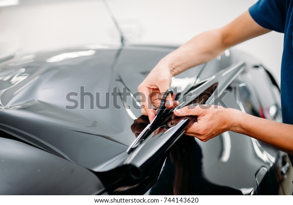 Male\
specialist with scissors, car tinting\
film
