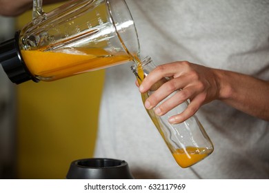 Male staff pouring juice in a bottle at health grocery shop - Powered by Shutterstock