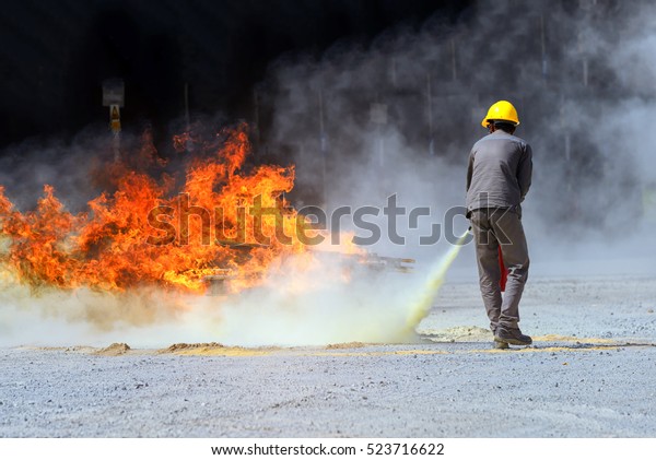 Male staff used fire extinguishers to\
extinguish the fire , Basic fire Training Course .\
