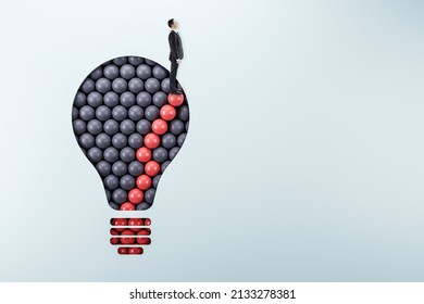 Male standing on abstract pattern light bulb on light background with mock up place. Idea, growth and success concept